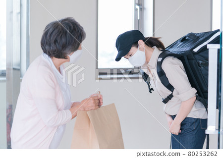 Senior woman receiving a delivery order Senior woman receiving a delivery order 80253262
