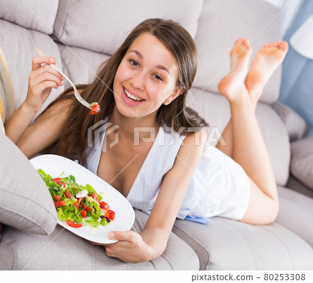 Sporty girl is enjoying tasty green salad 80253308
