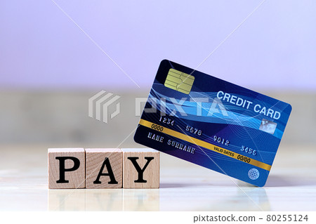 Mock up blue credit card and wood cube letter put on wooden table with spending via credit card Instead of cash concept 80255124
