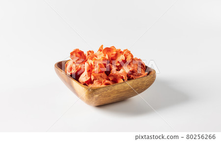Dried carrot chips in a wooden bowl on a white background. Vegetarian diet food. Horizontal orientation with copy space. Dried carrot chips in a wooden bowl on a white background. Vegetarian diet food. Horizontal orientation with copy space. 80256266
