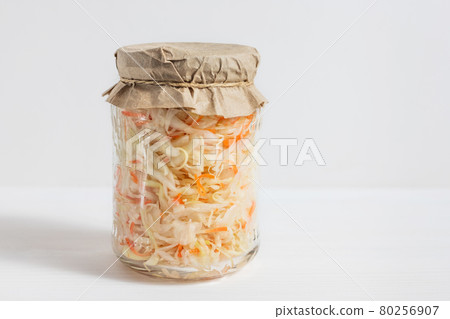 Homemade sauerkraut. Fermented food. Sauerkraut with carrots in a glass jar on a white wooden background Homemade sauerkraut. Fermented food. Sauerkraut with carrots in a glass jar on a white wooden background 80256907