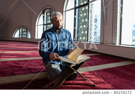 muslim man praying Allah alone inside the mosque and reading islamic holly book muslim man praying Allah alone inside the mosque and reading islamic holly book 80258172