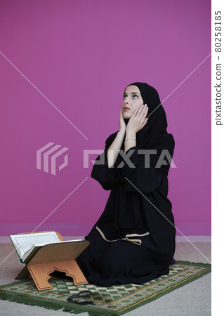 Middle eastern woman praying and reading the holy Quran Middle eastern woman praying and reading the holy Quran 80258185