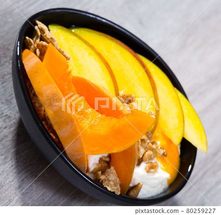 Breakfast with pumpkin and mango served with whipped topping and oat flakes Breakfast with pumpkin and mango served with whipped topping and oat flakes 80259227