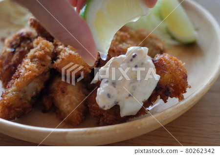 Squeeze the lemon into the fried oysters Squeeze the lemon into the fried oysters 80262342
