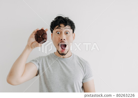 Wow and Shocked face of man feels excited with the huge chocolate cookie. Wow and Shocked face of man feels excited with the huge chocolate cookie. 80263226