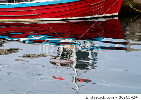 Old Red Boat and Reflections in a Small Coastal Harbour 80265424