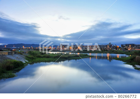 On the surface of the river in Guangguang, the light of dawn on the earth, clear blue sky and white clouds in the sky, street lights on the ground, and the reflection on the water surface. 80266772