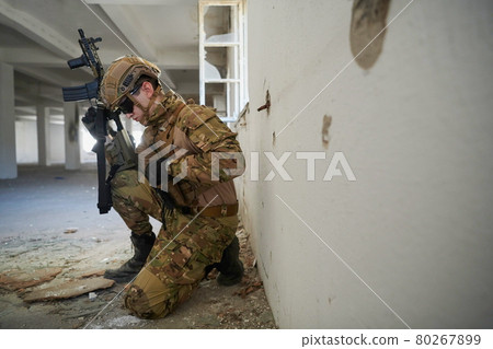 soldier in action near window changing magazine and take cover 80267899