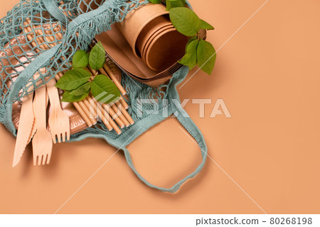 Kraft paper food cups and containers with wooden cutlery in cotton net bag on kraft paper background with copy space - eco-friendly tableware. Street food take away paper packaging 80268198