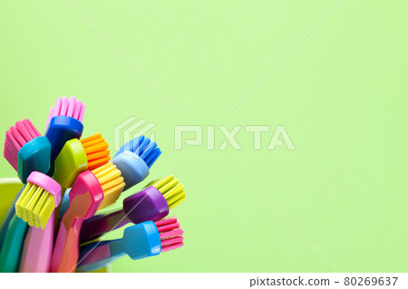 New Toothbrushes In Cup Over Green Background New Toothbrushes In Cup Over Green Background 80269637