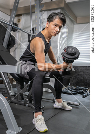 Middle-aged man training with dumbbells at the gym Middle-aged man training with dumbbells at the gym 80271563