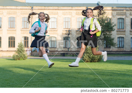 Excited happy girls school uniform jumping, sincere happiness concept Excited happy girls school uniform jumping, sincere happiness concept 80271773