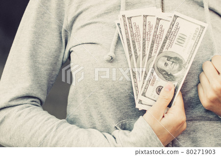 Close up of US hundred-dollar bills in hand. Woman presses to itself banknotes. 80271903