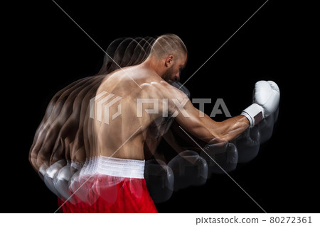 Young professional male boxer in red shorts and gloves training, exercising over black studio background. Stroboscope 80272361