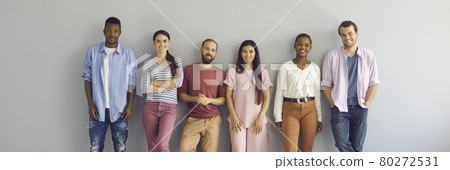 Banner with portrait of happy young people in casual clothes standing against studio wall Banner with portrait of happy young people in casual clothes standing against studio wall 80272531