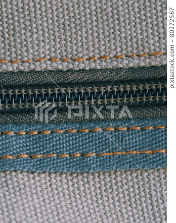 A zipper, zip, fly, or zip fastener, known as a clasp locker, is a commonly used device for binding the edges of an opening of fabric. Close-up. A zipper, zip, fly, or zip fastener, known as a clasp locker, is a commonly used device for binding the edges of an opening of fabric. Close-up. 80272567