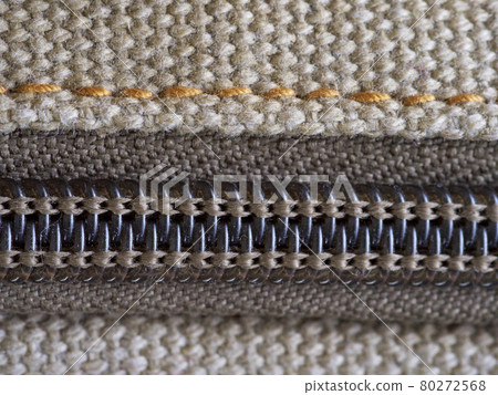 A zipper, zip, fly, or zip fastener, known as a clasp locker, is a commonly used device for binding the edges of an opening of fabric. Close-up. 80272568