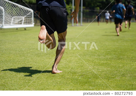 Runner running barefoot on the grass 80272793