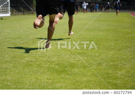 Runner running barefoot on the grass 80272794