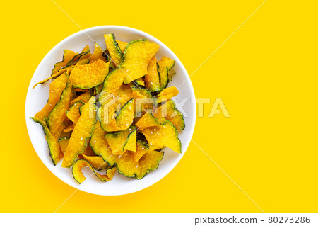 Green pumpkin slice chips in white plate on white background. Green pumpkin slice chips in white plate on white background. 80273286