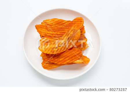 Spicy snack, Banana slice chips paprika flavor in white plate on white background. 80273287