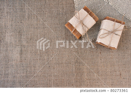 Top view on handmade natural soap bars or dry shampoo with on rustic fabric background with copy space. Close up of home spa products made with natural ingridients and organic essential oils 80273361