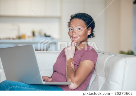 Cute young woman working on a laptop and looking thoughtful Cute young woman working on a laptop and looking thoughtful 80273662