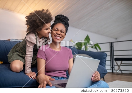 Happy mom with laptop and little daughter 80273830