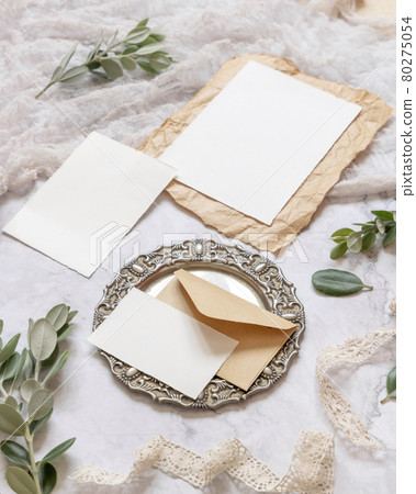Wedding blank cards laying on a marble table decorated with eucalyptus branches 80275054
