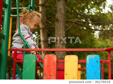 The little cute toddler child goes on the steps of the playground in the park 80276638