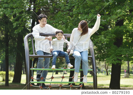 Young family snuggling up in the park 80279193