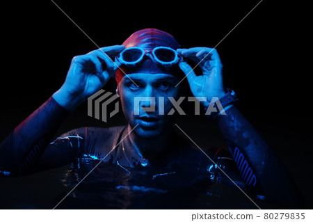 authentic triathlete swimmer having a break during hard training on night neon gel light authentic triathlete swimmer having a break during hard training on night neon gel light 80279835