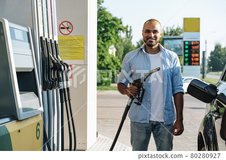 Man filling gasoline fuel in car at gas station 80280927