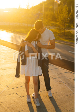 Vertical portrait of charming young couple in love hugging in summer evening on background of warm sunlight. 80282917