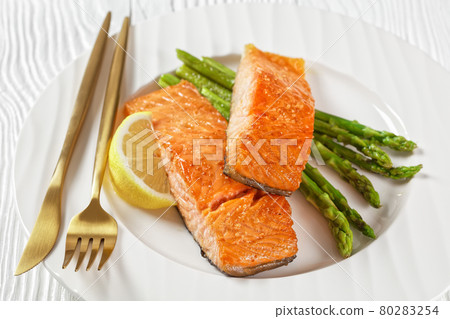 roast salmon fillets with lemon and asparagus 80283254