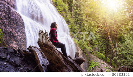 Woman watching the Waterfall in the Canadian rainforest. Woman watching the Waterfall in the Canadian rainforest. 80283391