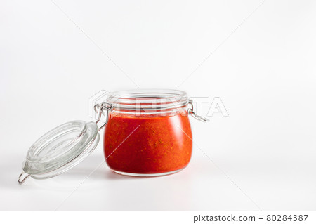 Hot chili pepper sauce paste harissa. Adjika. Traditional Tunisia, Georgian and Arabic cuisine. Homemade rose harissa in a glass jar. 80284387
