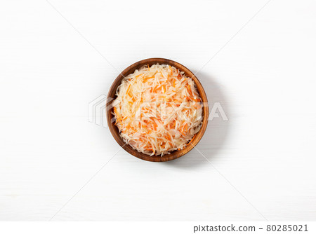 Homemade sauerkraut. Fermented food. Sauerkraut with carrots in a wooden bowl on a white background. Homemade sauerkraut. Fermented food. Sauerkraut with carrots in a wooden bowl on a white background. 80285021
