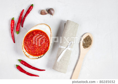 Hot chili pepper sauce paste harissa. Adjika on a white background. Traditional Tunisia, Georgian and Arabic cuisine. Homemade rose harissa in a bowl. Hot chili pepper sauce paste harissa. Adjika on a white background. Traditional Tunisia, Georgian and Arabic cuisine. Homemade rose harissa in a bowl. 80285032