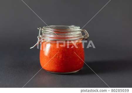 Hot chili pepper sauce paste harissa. Adjika. Traditional Tunisia, Georgian and Arabic cuisine. Homemade rose harissa in a glass jar. Hot chili pepper sauce paste harissa. Adjika. Traditional Tunisia, Georgian and Arabic cuisine. Homemade rose harissa in a glass jar. 80285039