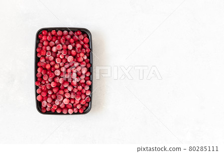 Frozen berries in a black plastic container on a white background. Vitamins. Frozen food. Copy space, top view. Frozen berries in a black plastic container on a white background. Vitamins. Frozen food. Copy space, top view. 80285111
