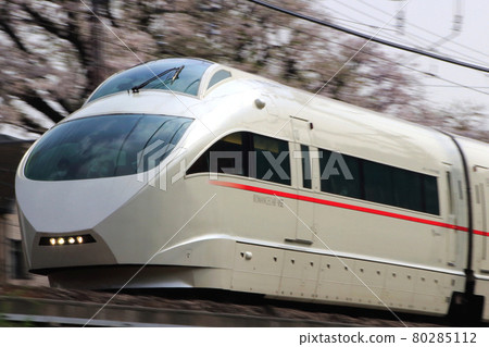 A row of cherry blossom trees and Odakyu Romance Car (50000 type VSE car) 80285112