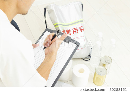 A man checking disaster prevention supplies A man checking disaster prevention supplies 80288161