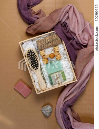 A gift set of eco-friendly products for skin and hair care. Dry shampoo, natural washcloth, wooden comb. On a craft background, with space, vertical 80290633