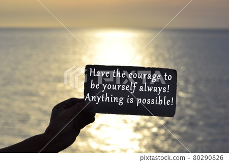 Text on hand holding dark torn paper with blurred background of sunset at the beach Text on hand holding dark torn paper with blurred background of sunset at the beach 80290826