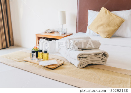 Group set of free hotel amenities (such as towels, shampoo, soap, gel etc) on the bed. Hotel amenities is something of a premium nature provided in addition to the room when renting a room. Group set of free hotel amenities (such as towels, shampoo, soap, gel etc) on the bed. Hotel amenities is something of a premium nature provided in addition to the room when renting a room. 80292188