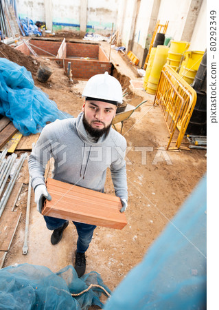 Builder working with red brick 80292349