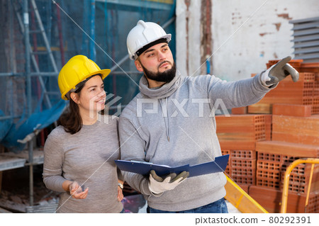 Engineers discussing blueprint at construction site Engineers discussing blueprint at construction site 80292391