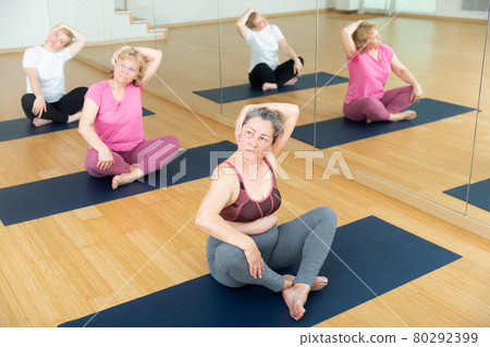 Scene of group of people practicing yoga - vakrasana pose 80292399